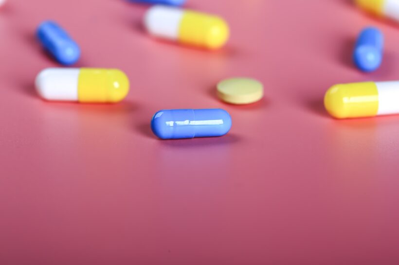 Yellow and blue pills on a pink background.