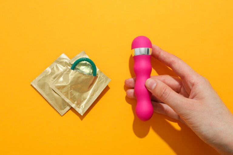 Bevezetés a vibrátorok világába Condoms and vibrator on a yellow background