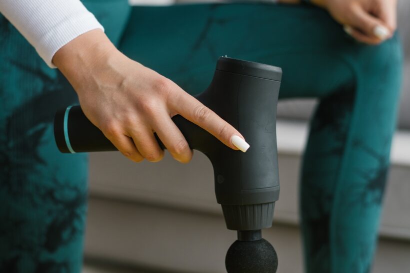 Female Massage Therapist does Massage Exercises on the Hips with the Help of Shock Vibrator Massager