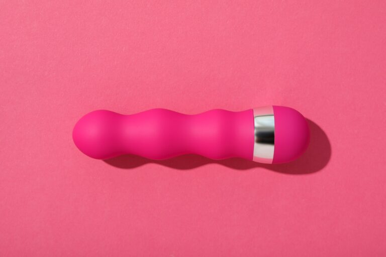 Bevezetés a vibrátor fóbiába Pink silicone vibrator on a pink background.